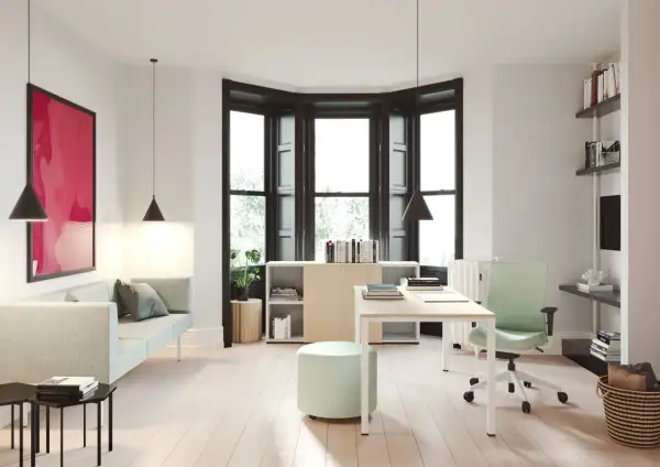 Un moderno despacho en casa con sofá, escritorio, silla ergonómica y estanterías.